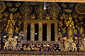 Wat Xieng Thong temple in Luang Prabang, Laos. Detail of the  intricate gold stencilling on black lacquer that decorate the walls of the sim.